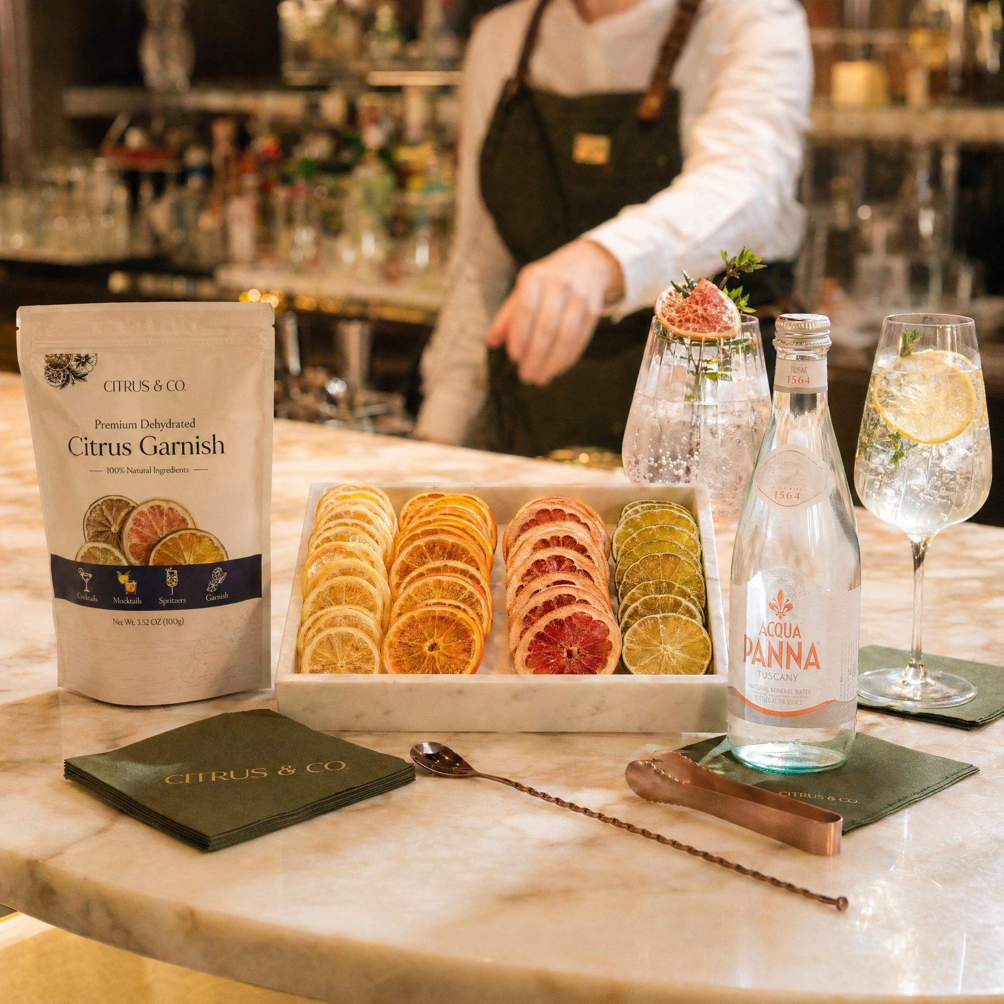 Upscale hospitality bar setup with a garnish tray of dehydrated citrus wheels.